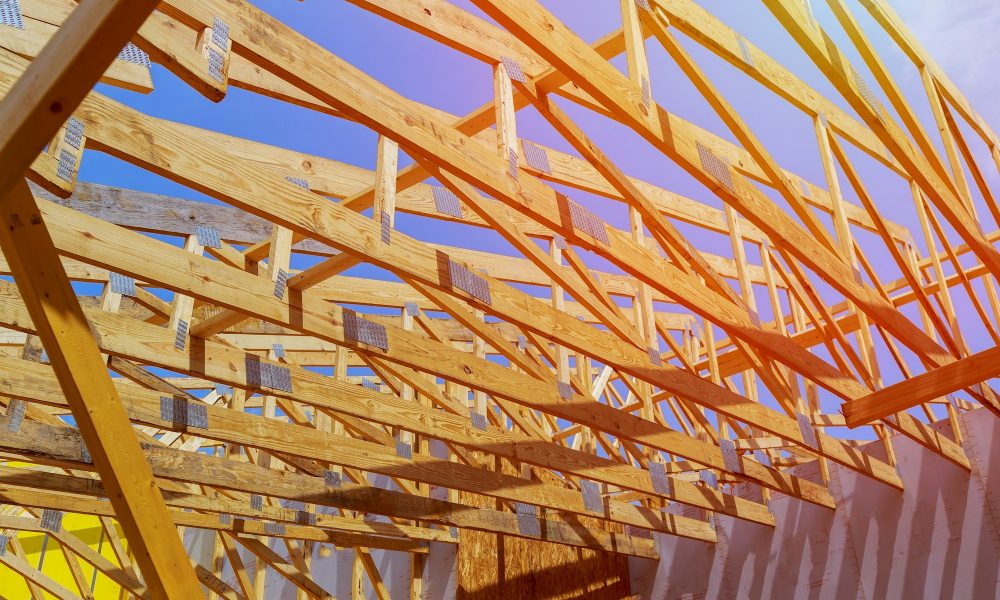 A stick built house under construction New build with wooden truss, post and beam framework.