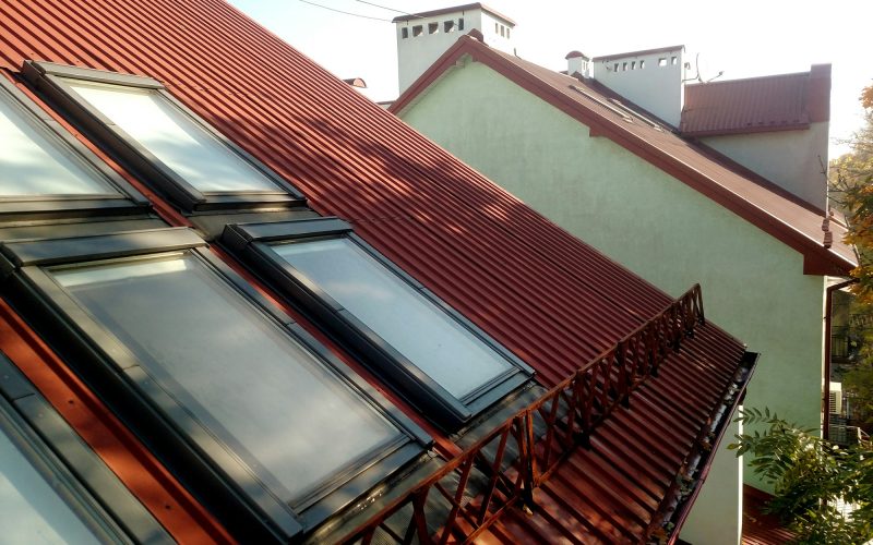 Red tiled house roof with attic windows. Roofing construction, window installation