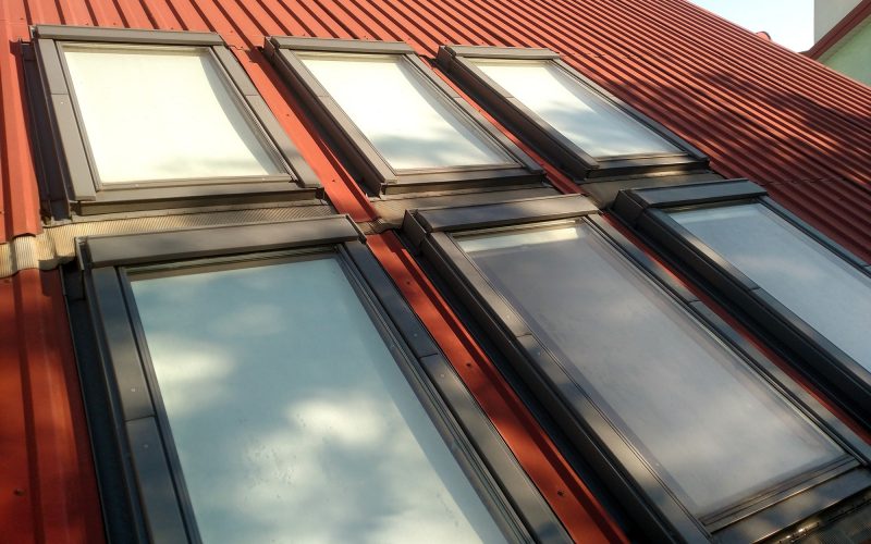 Roofing construction, window installation, modern architecture concept.